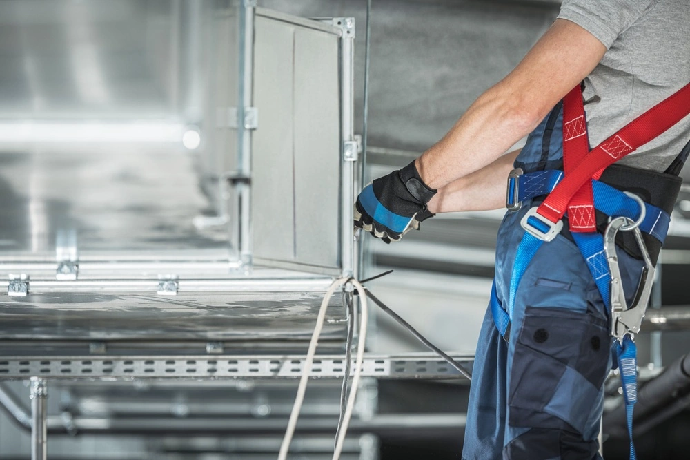 HVAC technician servicing an air conditioner to ensure a cool and comfortable indoor environment.