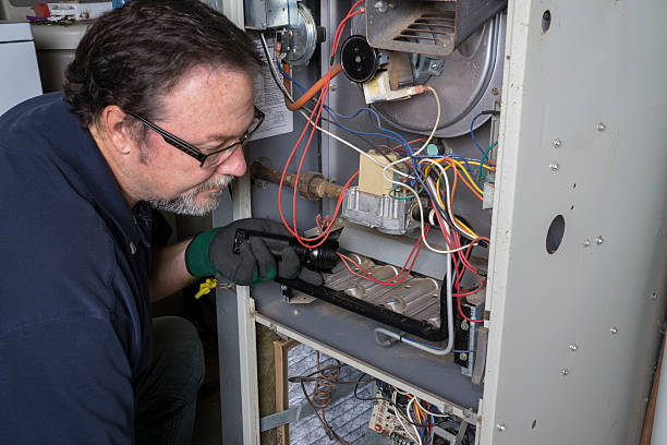Licensed technician repairing residential furnace system by Elevate Heating